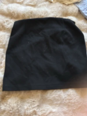 Svart kortkjol från 157 - Enkel och stilren svart kortkjol från 157. Kjolen har en rak passform och är tillverkad i ett mjukt material som känns bekvämt mot huden. Perfekt att matcha med en crop top eller hoodie för en chill look.