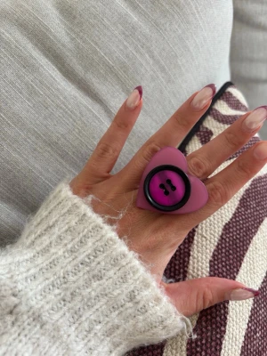 Ring med knapp - Säljer denna handgjorda ring.  Knapparna är vintage men själva ringen/ringstommen är helt ny och oanvänd. Materialet är rostfritt stål och varken tappar färg eller färgar av sig på huden. Ringen tål vatten. Storleken är justerbar, man kan trycka ihop och dra isär ringen till önskad storlek. Perfekt för dig som vill bära något unikt!