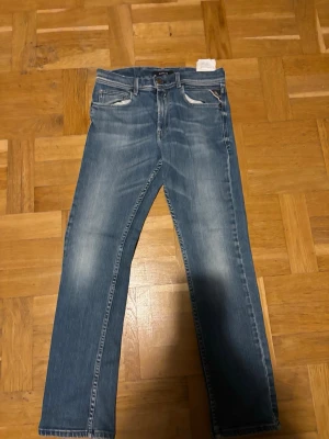 Replay jeans  - Snygga blå jeans med raka ben och lätt slitna detaljer vid fickorna. Klassisk femficksmodell med ljus tvätt och kontrastsömmar. Perfekta för en avslappnad stil och passar till det mesta. Materialet är denim.