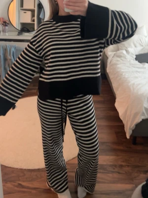 Randigt svartvitt loungewear-set - Mysigt loungewear-set med svart och vita horisontella ränder. Tröjan har vida ärmar och breda muddar, byxorna är raka med dragsko i midjan. Perfekt för chill dagar hemma. Mjukt och stretchigt material för extra komfort. Kan tänka mig att gå ner i pris vid SNABB affär 