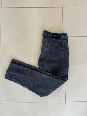 Jacob Cohen Jeans  - Ruggigt stiliga manchesterbyxor från Jacob Cohen i grå färg. Byxorna har en mjuk och skön känsla tack vare det ribbade manchestertyget och har en riktig bra passform. Dessutom är badgen riktigt fet. Längd - 97 cm och bredd 46 cm 