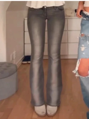 Grå bootcut jeans med utsvängda ben - Cheap Monday Snygga grå bootcut 25/32 jeans med utsvängda ben och klassisk femficksmodell. Jeansen har en hög midja och är tillverkade i stretchigt denimtyg som sitter tajt upptill och släpper ut vid knäna. Perfekta för en trendig och avslappnad look.
