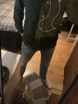 Mörkgrön utilityjacka med fickor - Snygg mörkgrön utilityjacka från Jack & Jones med fyra framfickor, dragkedja och knappar framtill. Jackan har en rak passform och ståkrage med tryckknappar. Perfekt för lager på lager och för en lite stiligare stil. Priset är itne hugget i sten.
