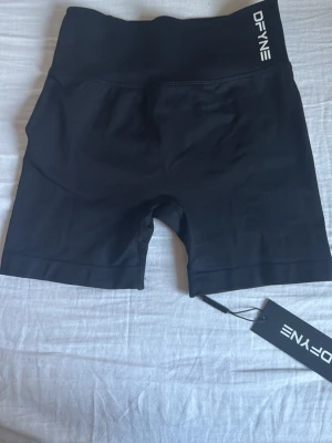 Dynamic shorts från DFYNE - Snygga svarta cykelshorts från DYFNE. Men har tyvärr aldrig använt pga storleken. Shortsen är tillverkade i ett stretchigt syntetmaterial och har scrunch-detalj bak för extra form. Perfekta för gymmet eller andra träningspass.
