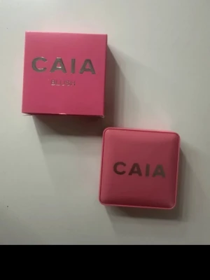 Caia Matte Blush Troublegum - Säljer ett CAIA Matte Blush i en snygg rosa fyrkantig dosa med spegel. Rouget har en matt finish och kommer i en mjuk rosa nyans. Perfekt för att ge kinderna en naturlig fräschör. Förpackningen är kompakt och enkel att ta med i väskan.