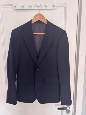 Kostym set - Tjena, säljer ett mörkblått kostym set från Dressmann i slim fit-modell. I setet ingår kavaj, skjorta och kostymbyxor. Kavajen har klassiska slag, två framfickor med lock och en bröstficka. Perfekt för dig som vill ha en snygg och modern look. Kostymsetet är endast använt en gång så det finns inga tecken på användning. På bilden var jag cirka 176 cm lång så den passar bra på dig som ligger runt där. Skriv angående frågor och funderingar 👍.