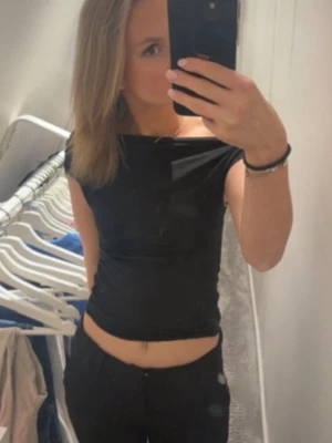 Svart croppad topp med offshoulder - Snygg svart croppad topp med offshoulder-design och tight passform. Perfekt att styla med höga jeans eller kjol. Tunn och stretchig, känns riktigt skön mot huden.