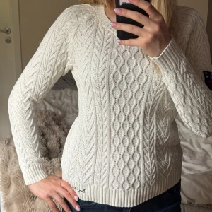 Vit kabelstickad tröja från Bondelid - Kabelstickad vit tröja från Bondelid med rund halsringning och ribbade muddar. 