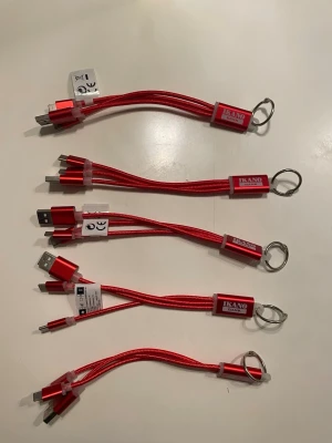 Röda multi-laddkablar med nyckelring - Säljer flera röda multi-laddkablar från Ikano Bank. Kablarna har USB och flera olika kontakter för laddning, perfekt att ha på nyckelringen. Tillverkade i metall och plast med snygg röd finish och metallring för enkel upphängning.