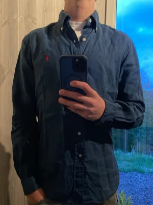 Polo Ralph lauren skjorta - Hallö! Säljer nu denna linne skjorta i snygg blå färg perfekt till sommaren, grabben på bilden är 175cm lång och väger 65kg. Har ni några funderingar är det bara att höra av dig😃
