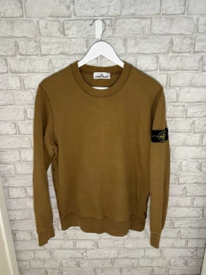 Stone Island tröja - Säljer nu en khaki sweatshirt ifrån Stone Island. Tröjan har den klassiska logotypen på vänster ärm och är gjord i mjuk bomull. Enkel och stilren design som passar perfekt till streetwear. Hör av dig vid intresse 🙌