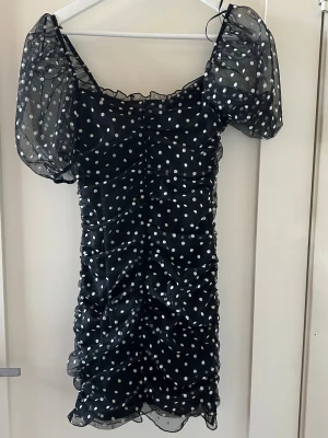 Klänning  - Kort prickig klänning ifrån H&M storlek XS men passar mig me S perfekt. Ej genomskinlig har extra tyg under oså puffärmar. Använd ett antal gånger men hel och fin. Stretchig är den!!