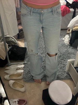 Ljusblå slitna bootcut jeans -  Slitna längst ner och finns en lite fläck som inte går bort