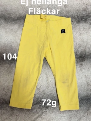 Gula leggings från Polarn O. Pyret - Snygga gula leggings från Polarn O. Pyret med elastisk midja och ett litet logomärke på höften. Perfekta för att skapa en färgglad och bekväm outfit. 🌸 Ej hellånga. Fläckar, storlek 104 