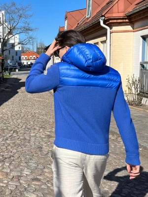 Blå hoodie från Moncler med huva - Säljer en blå hoodie från Moncler med stickad kropp och quiltad, glansig huva och axelparti. Tröjan har långärmade ribbade muddar och en half zip framtill. Moncler-logga på ärmen. Perfekt för dig som gillar exklusiva streetwear-vibbar. Sjukt unik ingen annan som har denna modellen, Äkta såklart. Moncler storlek L vilket motsvarar M/S. Är 180 väger 76 o den sitter perfekt 