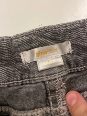 Grå jeansskort  har gårt skälvan  - Grå jeansskort från Gina Tricot med volangdetalj nedtill och klassiska femficksdetaljer. Gjord i denim med råa kanter för en trendig look. Perfekt för dig som gillar en edgy och avslappnad stil.
