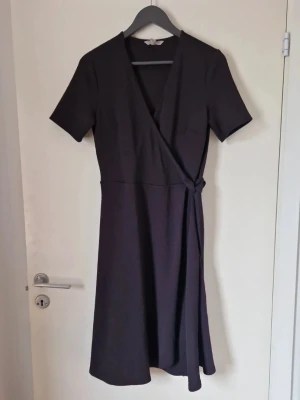 Omlottklänning - Bandet går att knyta. Storlek M. Köpt på Sellpy men jag har endast provat den och den är i fint skick. Den slutar precis vid knäna eller någon centimeter under på mig som är 168 cm lång ( syns på sista bilden ). Katt finns i hemmet