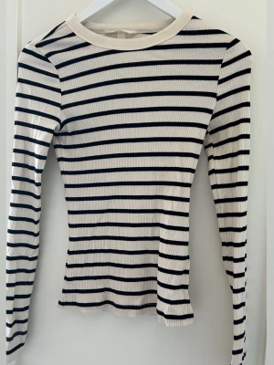 Randig tröja  - Randig stretchig långärmad tröja i storlek S från H&M. Sätter sig tajt på en, Använd ett antal gånger men hel och fin 
