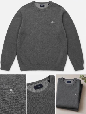 Grå stickad tröja från GANT - Snygg grå stickad tröja från GANT med rund halsringning och diskret broderad logga på bröstet. Tröjan har en klassisk passform och ribbade muddar vid ärmslut och nederkant. Perfekt för lager-på-lager och stilrena outfits.