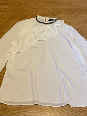 Vit blus med volang och pärldetalj - Vit blus från Zara med volangdetalj framtill och pärlprydd krage