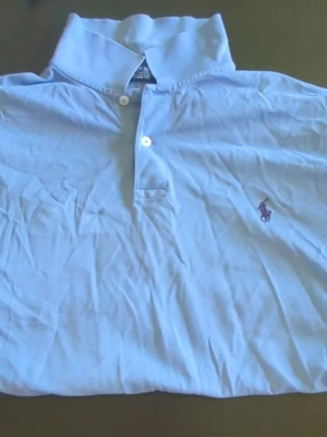 Ralph Lauren Piketröja - Klassisk ljusblå t-shirt från Ralph Lauren med korta ärmar och pikékrage. Tröjan har inga fel man märker. 