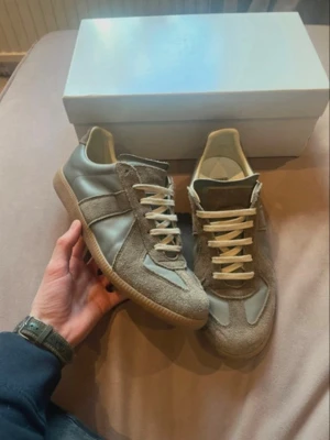 Gröna sneakers i mocka och läder - Snygga sneakers i grön mocka och slätt läder med vita snören och gummisula. Klassisk siluett med låg profil och neutrala färger som passar till det mesta. Perfekta för dig som gillar stilrena och tidlösa skor med en modern touch.-ingen låda medföljer. Lite sämre skick än på bilderna.