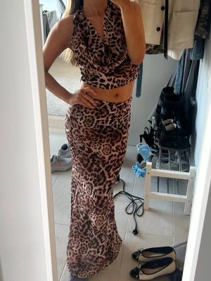 Leopardmönstrat set  - Säljer en croppad halternecktopp med leopardmönster och en kjol i samma mönster. Supernajs att ha utomlands!!!💞