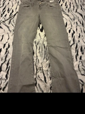 Grå jeans från LTB Valeria - Snygga grå jeans från LTB, modell Valeria. Klassisk femficksdesign med bootcut och låg midja. Jeansen har en enkel knappstängning och är tillverkade i mjukt denimtyg som är skönt att ha på sig w 30 l 30