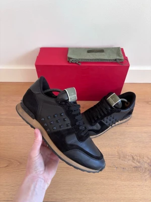 Svarta Valentino sneakers med nitar - Valentino Garavani Rockrunners i svart | Storlek: 43 | Skick: Bra skick. Nitarna är intakta (inga nitar har lossnat), kalvläder och mockadetaljer.| Ingår: Skor samt en Valentino Rockrunner dustbag | Vill du ha fler bilder eller mer info, skicka gärna DM så löser jag det
