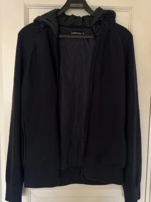 J.Lindeberg cardigan  - Marinblå cardigan jacka från J.Lindeberg med fodrad insida och fodrad luva, perfekt inför våren.