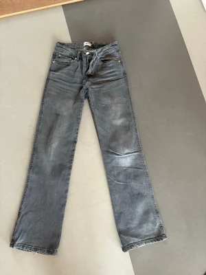 Mörkgrå jeans - Säljer ett par mörkgrå jeans från Lager 157 då de blivit för små för mig. Storlek XS. I gott skick, men lite slitna i nedre kant. 