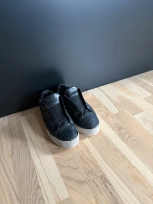 Svarta slip-on sneakers från Axel Arigato - Säljer ett par svarta axel arigato skor med läder skicket är 6/10