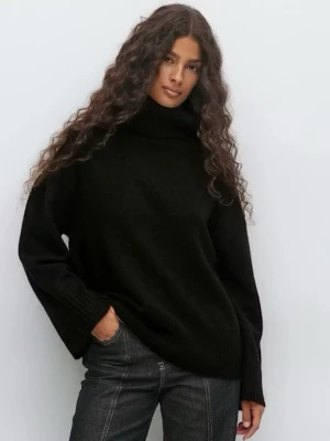 Svart polotröja GinaTricot - En svart oversized polotröja från GinaTricot. Tröjan har en hög krage, vida ärmar och är gjord i ett mjukt material som ger en avslappnad och trendig look. Köp för mindre än 1 månad sedan och endast använd 1 gång. 