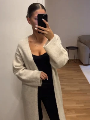 Beige kofta från VILA i stickat material❣️ - Mysig beige kofta från VILA i stickat material. Koftan har öppen front, långa ärmar och två praktiska fickor framtill. Perfekt att slänga över en topp för en chill och stilren look.