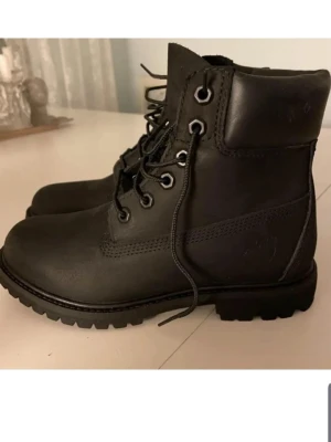 läderkängor med grov sula - Säljer ett par svarta kängor i läder med kraftig, mönstrad sula och snörning framtill. Kängorna har metallöljetter och hög skaft som ger en cool och robust look. Perfekta för dig som vill ha ett stilrent och slitstarkt par boots.