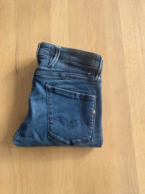 Replay Jeans - Snygga Blåa jeans från Replay med klassisk femficksdesign och en slim passform. Jeansen har en diskret tvättad look och är tillverkade i stretchigt denim för en bekväm passform. Perfekta för en stilren och modern look.