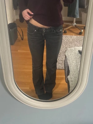 Mörkgrå bootcut jeans med fickor - Säljer ett par mörkgrå bootcut jeans med låg midja och klassiska fem fickor. Jeansen har snygga sömmar och detaljer på bakfickorna. Perfekta för dig som gillar en avslappnad men ändå trendig look. Storlek 158💕 säljer då de inte kommer till användning längre