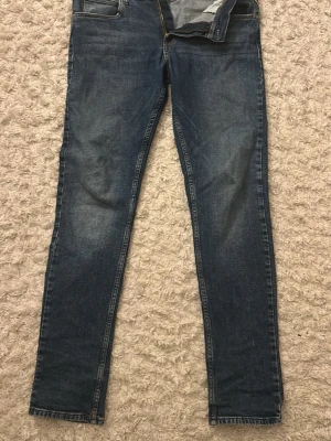 Blå skinny jeans från Replay - Snygga blå skinny jeans från Replay med klassisk femficksdesign och diskreta slitningar. Jeansen har en smal passform och är tillverkade i denim med stretch för extra komfort. Perfekta till vardagslooken och har en läderpatch med Replay-logga bak. Underskattade jeans ifall ni frågar mig