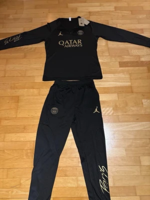 Svart PSG träningsset Jordan x Qatar - Snyggt svart träningsset från PSG och Jordan med guldfärgade detaljer och loggor. Storlek S-M. Kontakta mig för fler frågor😃