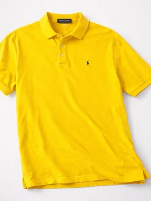 Gul pikétröja från Ralph Lauren - Klassisk gul pikétröja från Ralph Lauren med korta ärmar och krage. Tröjan har knappar framtill och den ikoniska lilla broderade loggan på bröstet. Perfekt till jeans eller shorts för en clean och sportig look.