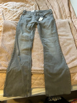 Helt nya jeans med prislapp – stl L - Helt nya gråa low boot jeans från Lager 157 med prislapp kvar, aldrig använda. jeansen är i storlek L med full length.   Nypris 400 kr, säljer för 250 kr. Pris kan diskuteras!   Säljs eftersom de tyvärr är för små för mig. Bild från hemsidan visar hur de sitter på.