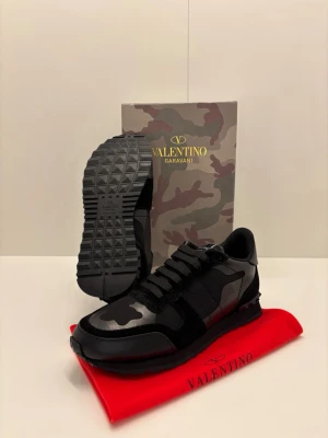 Valentino Rockrunners - Säljer ett par exklusiva Valentino Rockrunner i storlek 43, i mycket fint skick. Svart camo, premiumläder och mocka. Levereras med originalkartong och tillbehör. Stilrena, bekväma och ikoniska sneakers för dig som vill lyfta din outfit.