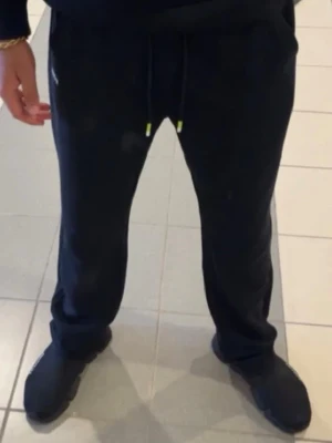 Svart hoodie från BOSS - Säljer en svart hoodie från BOSS med diskret logga på bröstet. Hoodien har huva med dragsko och en stor magficka. Tillverkad i mjukt material som känns skönt mot huden. Perfekt för en avslappnad och stilren look.