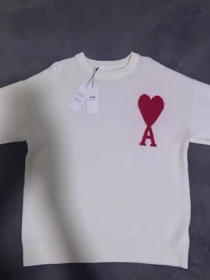 Vit Ami Paris knit  - Snygg vit stickad tröja från Ami Alexandre Mattiussi med röd hjärtloggan  och bokstaven A på bröstet.  100% bomull ✅ inga defekter ✅ Helt ny ✅ Ställ gärna frågor om plagget ifall ni har det!!