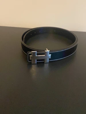 Svart skärp - Svart skärp med H emblem 120cm