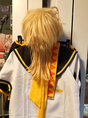Kagamine lek cosplay  - Säljer en cosplaydräkt av kagamine len. Ingår även en blond peruk med längre nacke. Peruken var stylad när jag köpte den så det är inte den snyggaste i stan men den funkar. Jag är en storlek S och den passade braVäldigt skön att ha på sig! 