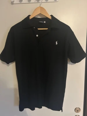 Svart pikétröja från Polo Ralph Lauren - Svart polo piké. Använt ett fåtal gånger. 