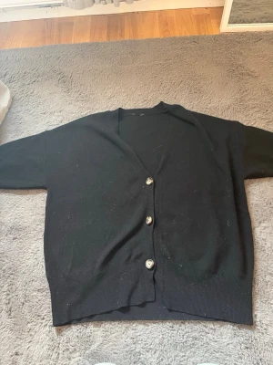 Svart kortärmad kofta  - Säljer en jätte fin kortärmad svart kofta. Den är lite nopprig och köpt secondhand för 300kr. Lappen är tyvärr avklippt så vet inte vart den är ifrån. Skulle uppskatta storleken som M/L. Tveka inte att skriva om ni undrar över något!❣️❣️pris kan alltid diskuteras!❣️