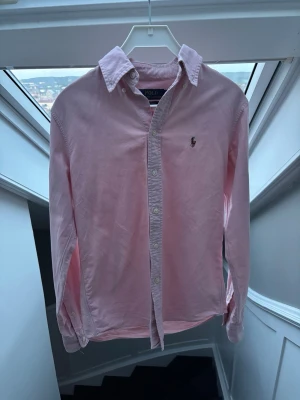 Rosa Ralph Lauren skjorta  - Otroligt snygg ljusrosa skjorta från Ralph lauren, perfekt nu inför sommaren🤩 sparsamt använd knappt några täcken på användning. Storlek XS. Pris 499 😍✅ skriv vid minsta fundering // Noel 