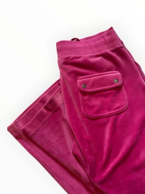 Rosa Juicy Couture - Juicy Couture hot pink byxor.  Fint Skick (9/10)  Väldigt sparsamt använt, endast fåtal gånger och inte mycket utomhus.  Storlek: M   📐Mått: Innerbenslängd: 83cm Midja: 36cm  Väldigt mycket stretch   DM vid funderingar 💕  Upp till 20% vid köp av bundles